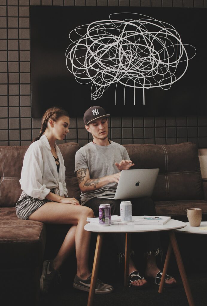 How Much do Sober Living Homes Cost, Two People Sitting on a Couch Looking at a Computer Screen, Foundations Wellness Center